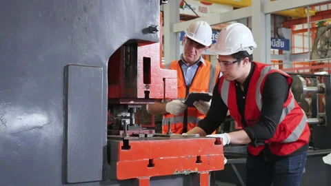 Workers use industrial machinery to make the pieces under the supervision. Stock Footage 172575405