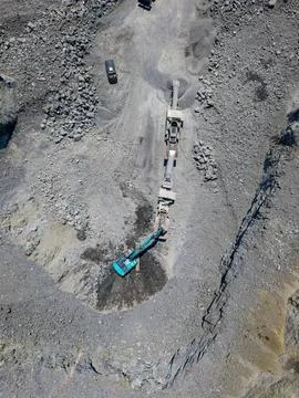 Workers use machinery to extract granite at a quarry in a remote location d.. Stock Photos