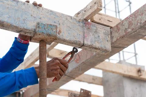 Workers use scaffolding wire to support the floor pouring concrete. Stock Photos