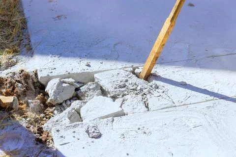 Workers use tools to break concrete during construction at building site Stock Photos