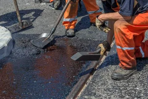 Workers using a asphalt tool to spread mastic asphalt Stock Photos