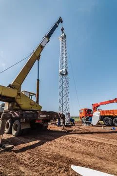 Workers using construction equipment install a wind generator Stock Photos