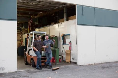 Workers using digital tablet at warehouse loading dock Stock Photos