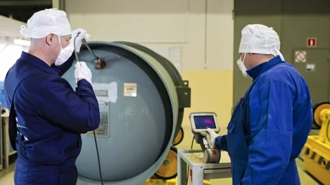 Workers Using Endoscopes Inside A Gas Centrifuge To Control Production Process Stock Footage 156159025