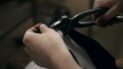 Workers using a handtool to working on shoe component in footwear factory Stock Footage 98568929