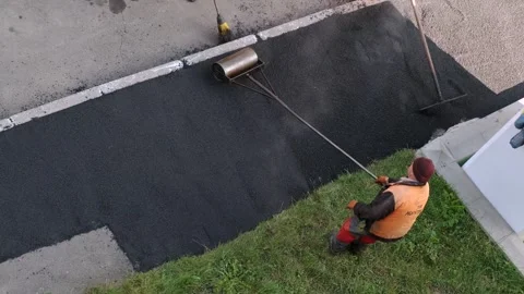 Workers using manual roller and rake to lay fresh asphalt on sidewalk Video stock 339802275