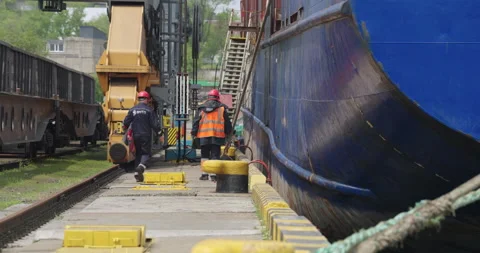 Workers walk along narrow dock between ship and train Stock Footage 319832296
