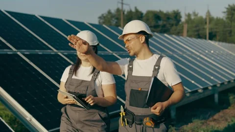 Workers walk through the plant's solar panels and analyze its performance Stock Footage 256108546