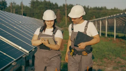 Workers walk through the plant's solar panels and analyze its performance Stock Footage 256834911