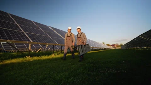 Workers Walk Through Solar Station Carrying Tools Stock Footage 296850023