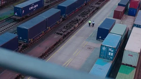 Workers Walking Along Container Trains at Freight Terminal From Aerial Perspecti Stock Footage 334053531