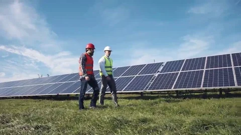Workers walking in between rows of solar panels Stock Footage 69079591