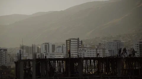 Workers Walking on Concrete Slab at Construction Site with Mountains 動画素材 310406317
