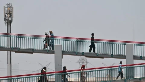Workers walking over a footbridge linking labour accommodation to Dubai city. Stock Footage 341625059