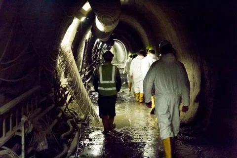 Workers walking in an underground tunnel Stock Photos