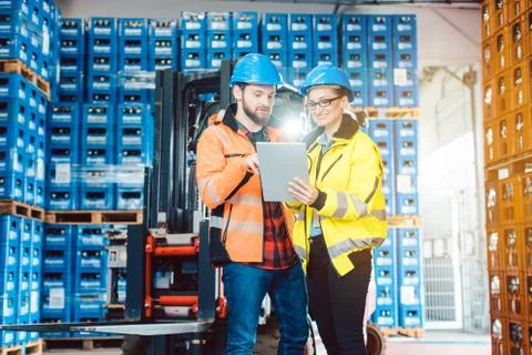 Workers in warehouse checking data on tablet computer Stock Photos