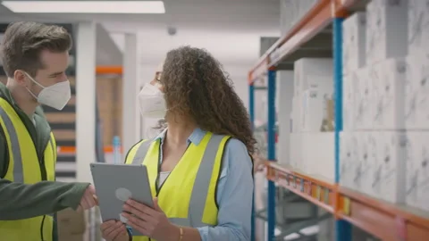 Workers In Warehouse Training Male Intern Standing By Shelves All Wearing Face Stock Footage 179640880