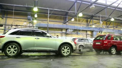 Workers wash with streams of water some cars on car wash Stockbeeldmateriaal 10808567