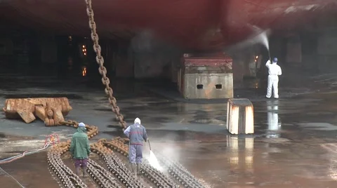 Workers washing ship and anchor chain in dry dock Stock Footage 61543370