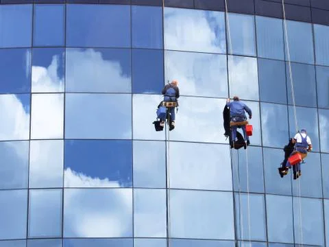 Workers washing a skyscraper windows Stock Photos
