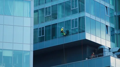 Workers washing skyscraper's windows Stock Footage 124010157