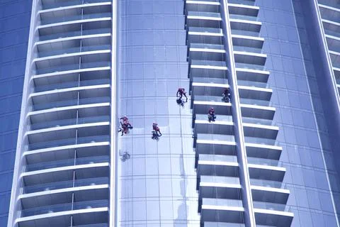 Workers washing the windows facae of a modern office building Stock Photos