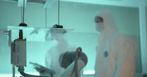Workers watch robot arm hits up glass for monitor's screen in laboratory Stock Footage 232782458