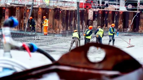 Workers wearing PPE at construction site foundation pouring leveling of concrete Vídeos de archivo 325056248