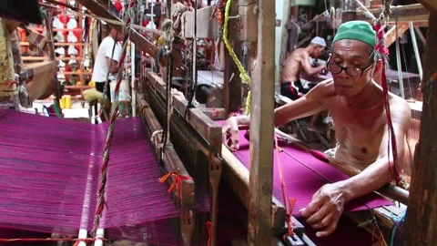 Workers weaving thread into cloth using traditional looms Video stock 139435124