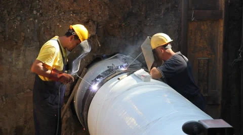 Workers welding pipe, teamwork Stock Footage 31204380