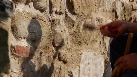 Workers who clean the plaster on the a wall of stone and brick, with a Stock Footage 71339819