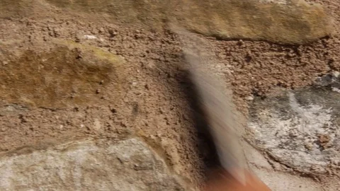 Workers who clean the plaster on the a wall of stone and brick, with a Vídeo Stock 71344493