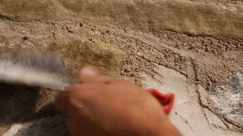 Workers who clean the plaster on the a wall of stone and brick with a wire br Stock Footage 71756862
