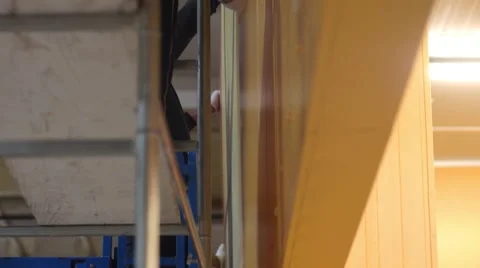 Workers who work on a scaffold bringing a wooden panel on which it will be mo Stock Footage 68454176