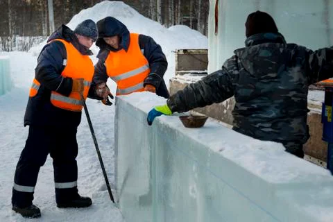 Workers in winter workwear installing ice panels Stock-Fotos