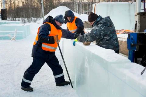 Workers in winter workwear installing ice panels 스톡 사진