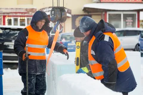 Workers in winter workwear installing ice panels 스톡 사진