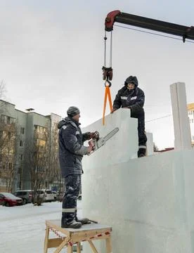 Workers in winter workwear installing ice panels 写真素材