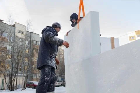 Workers in winter workwear installing ice panels 写真素材