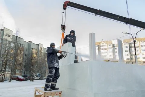 Workers in winter workwear installing ice panels Stock Photos