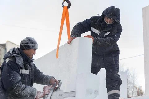 Workers in winter workwear installing ice panels 스톡 사진