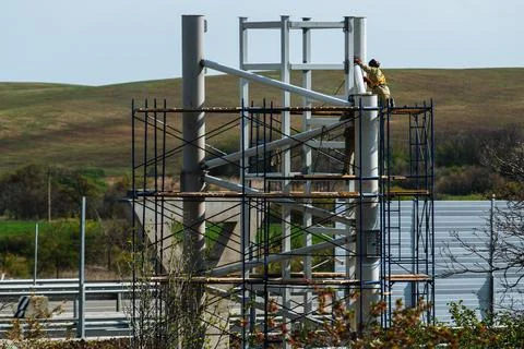 Workers work at a construction site while on scaffolding.Metal construction Stock Photos