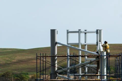 Workers work at a construction site while on scaffolding.Metal construction Foto stock