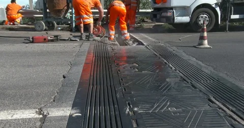 Workers at work on the road, repairing an expansion joint on a bridge, Stock Footage 83499472