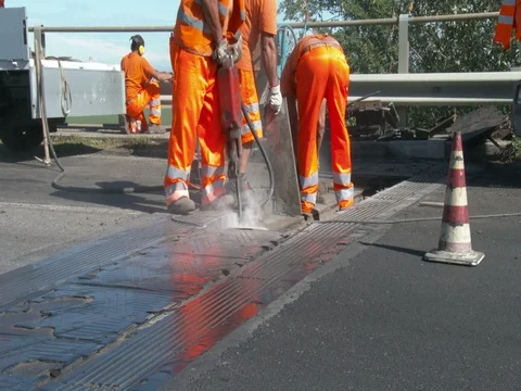 Workers at work on the road, repairing an expansion joint on a bridge, Video stock 83499563