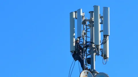 Workers working on a cellular signal antenna in a country under a blue sunny sky Stock Footage 123150142
