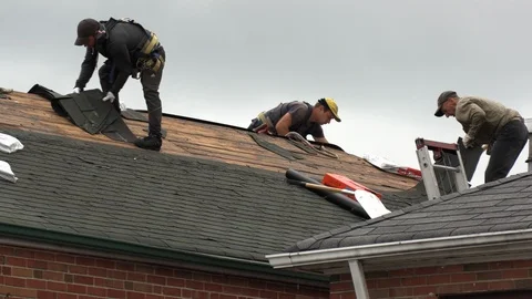 Workers working on hot summer day installing shingles on roof of house Stock Footage 98267870