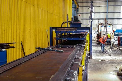 Workers working on the production of roofing sheets inside the warehouse Stock Photos