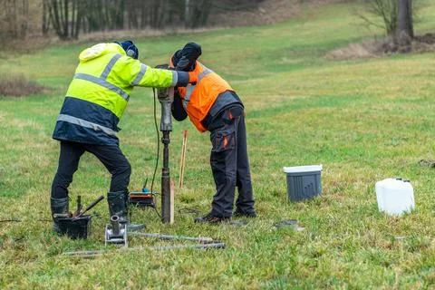 Workers working with a soil sampling drill Foto stock