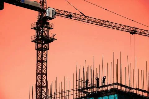 Workers working under Cranes on construction site Stock Photos
